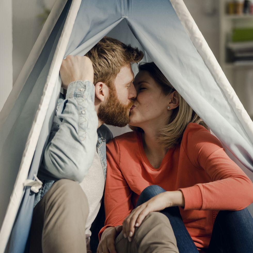 indoor date night - Happy couple at home camping ina tent in the livingroom