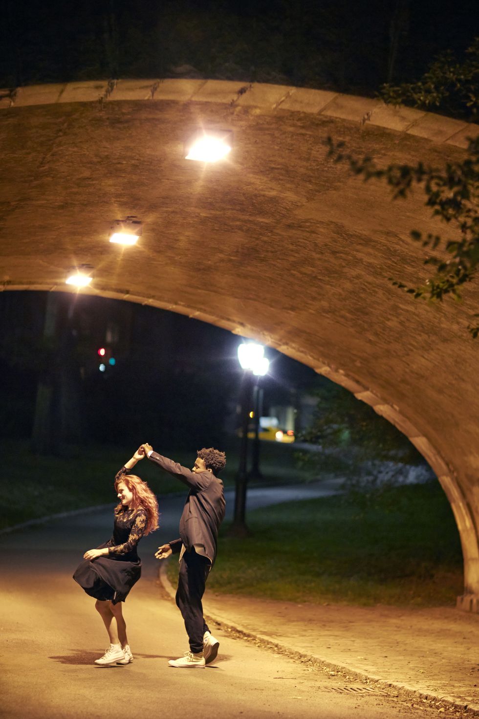 happy couple dancing on street at night