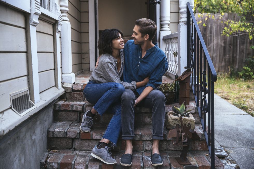 Happy couple sitting on stoop embracing