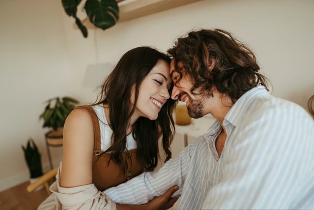 happy couple touching foreheads at home