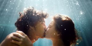 man en vrouw kussen in het water 