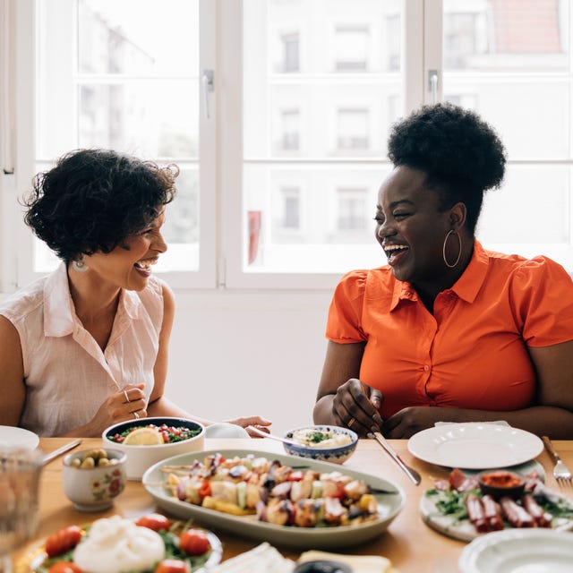 happy diverse friends sitting at the table and talking to each other