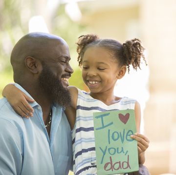 happy father's day girl gives card to dad
