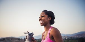happy female runner holding water bottle