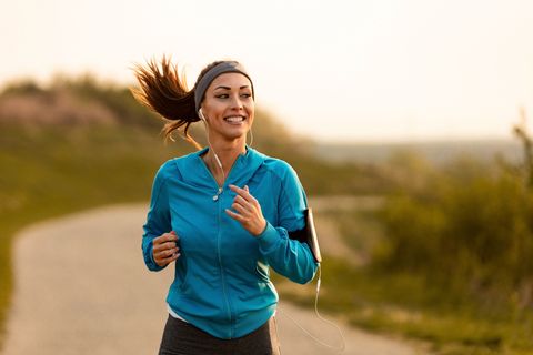 happy female runner jogging in the morning in nature
