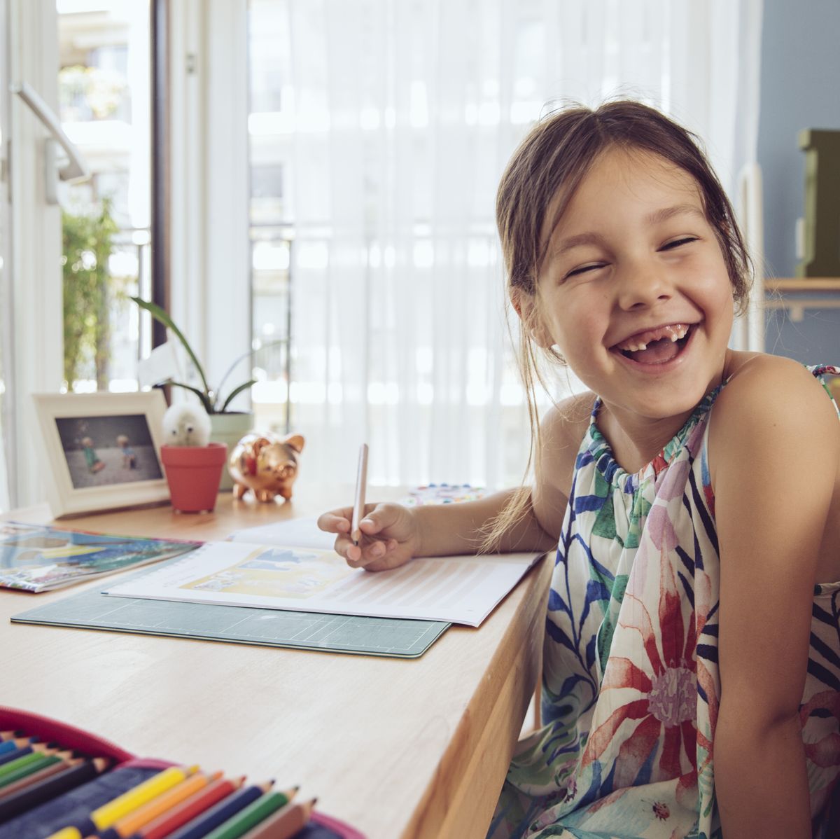 https://hips.hearstapps.com/hmg-prod/images/happy-girl-doing-her-schoolwork-at-home-royalty-free-image-1627678308.jpg?crop=0.668xw:1.00xh;0.332xw,0&resize=1200:*