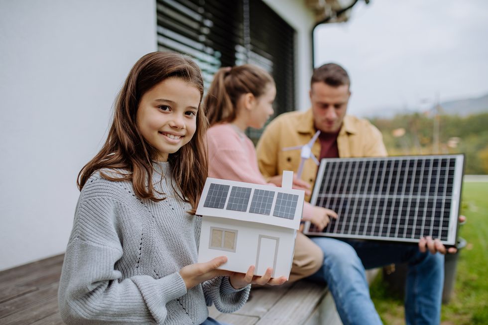 nina con su familia y placas solares