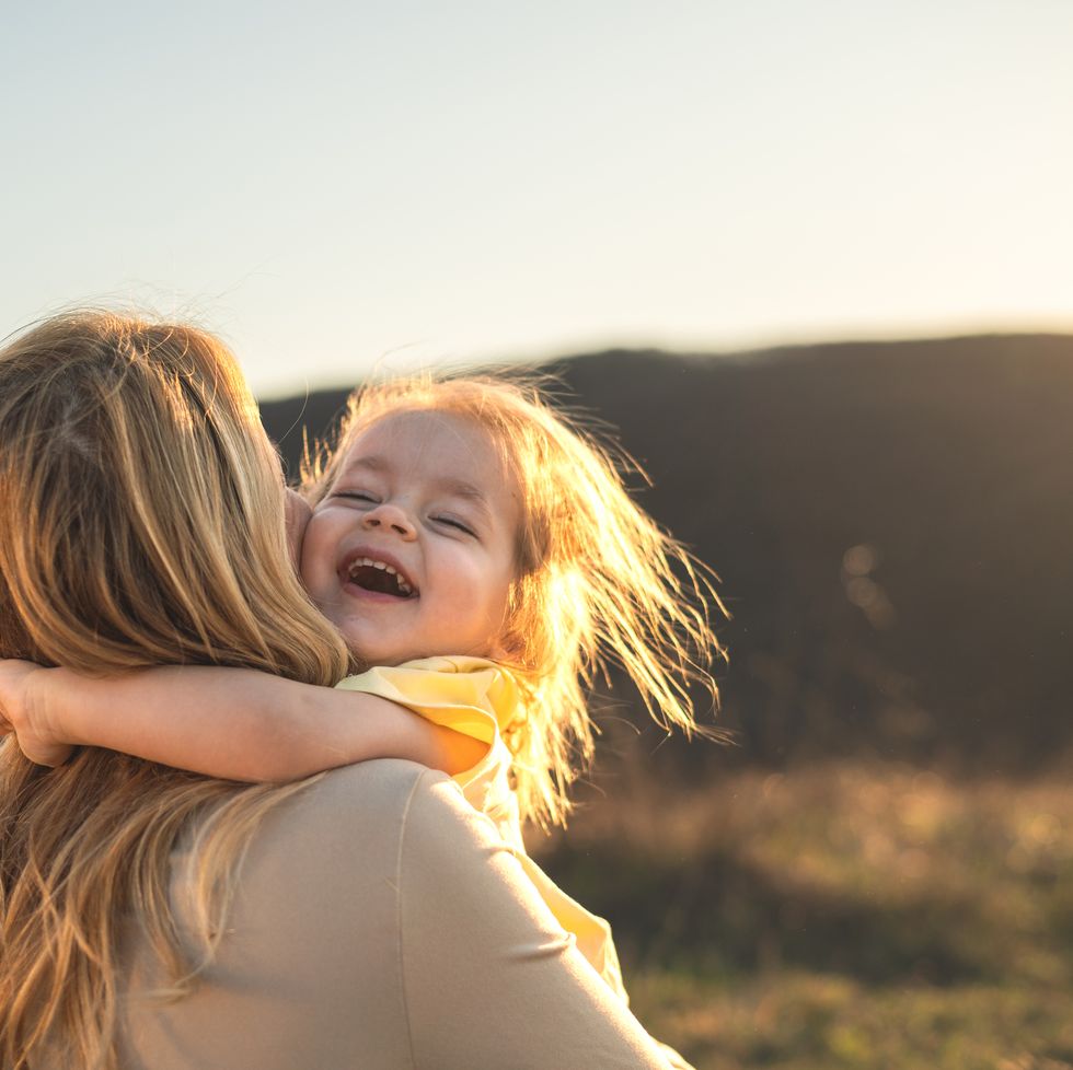 happy girl kid hugging mom in the nature