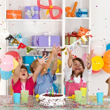 happy group of children catching confetti at birthday party