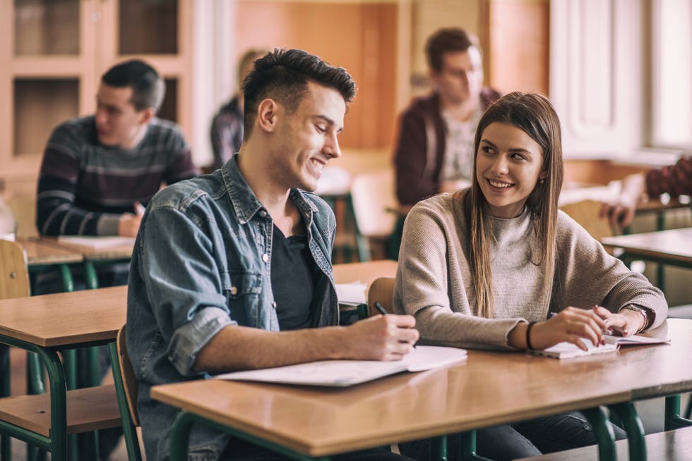 happy high school friends talking in the classroom