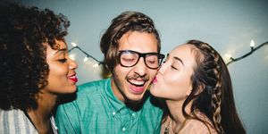 happy man enjoying kiss on cheek from female friend at home during party