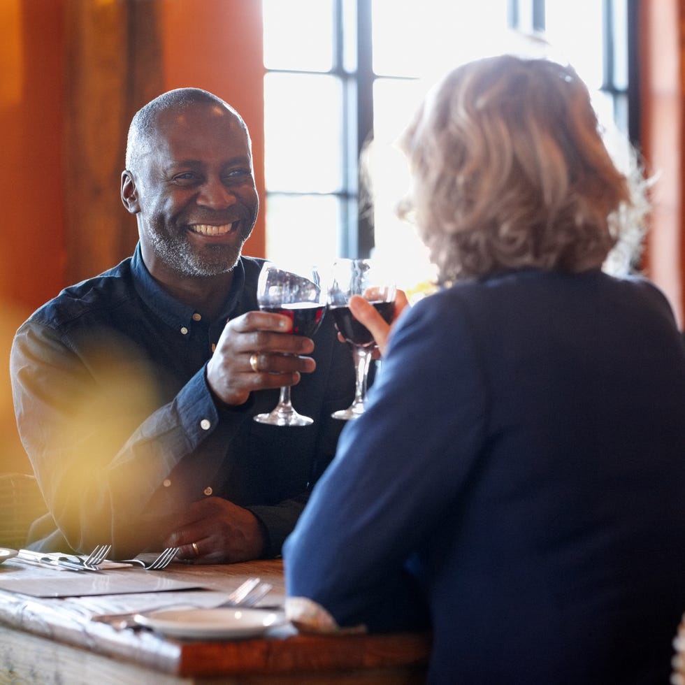 Happy mature couple enjoying wine in pub