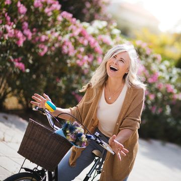 Happy mature woman enjoying bike ride with vintage bicycle