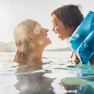 happy mother and son having fun while swimming in sea on summer vacation