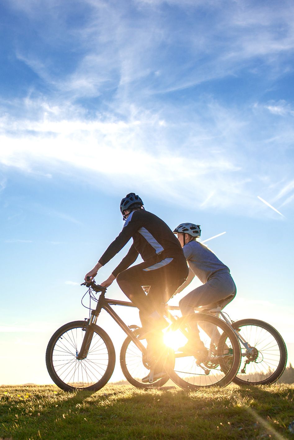 Happy mountain bike couple outdoors have fun together on a summer afternoon sunset