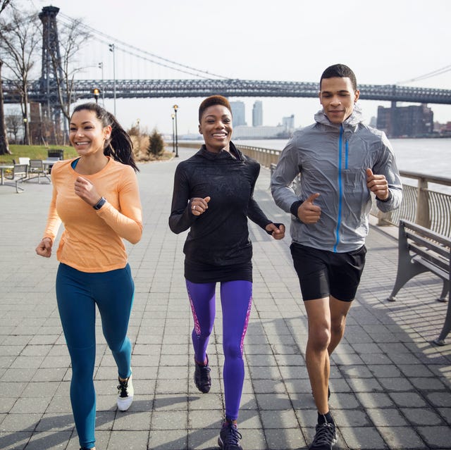 Happy multi-ethnic athletes running on footpath with Williamsburg Bridge in background runners blood work happy multi ethnic athletes running on footpath with williamsburg bridge in background