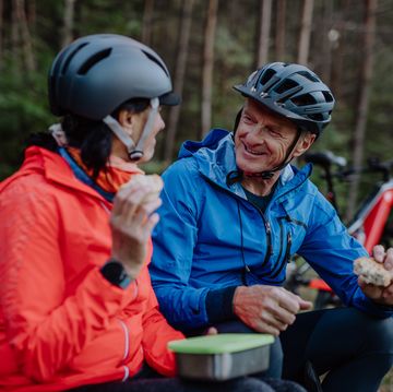 protein intake seniors happy senior couple bikers with eating snack outdoors in forest in autumn day