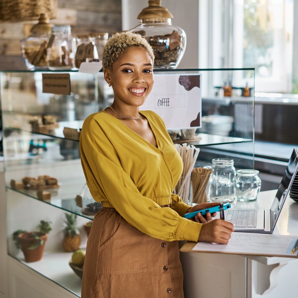 happy small business owner working on the finance budget and growth of her coffee shop portrait of an excited female entrepreneur ordering stock for her cafe and is satisfied with the progress