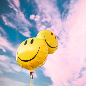 happy smiley face balloons against colorful cotton candy sky, happiness