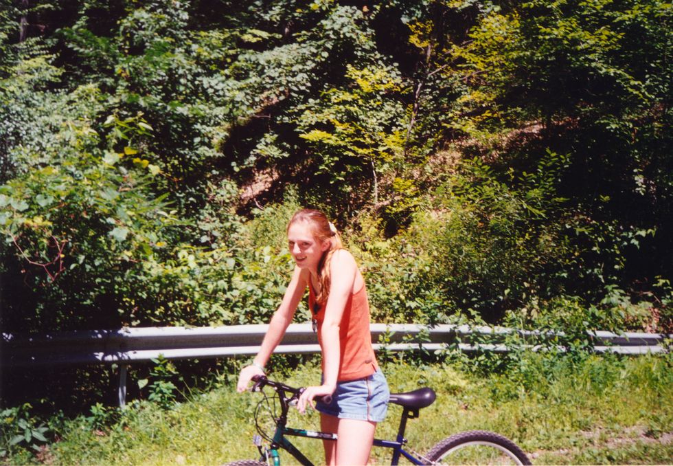 happy teen riding bike, vintage 2000s style y2k candid teenager having fun outdoors, active lifestyle on bicycle