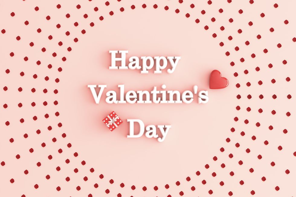 heart, gift, and white letters spelling happy valentine's day on pink surface encircled by red dots arranged in spoke pattern