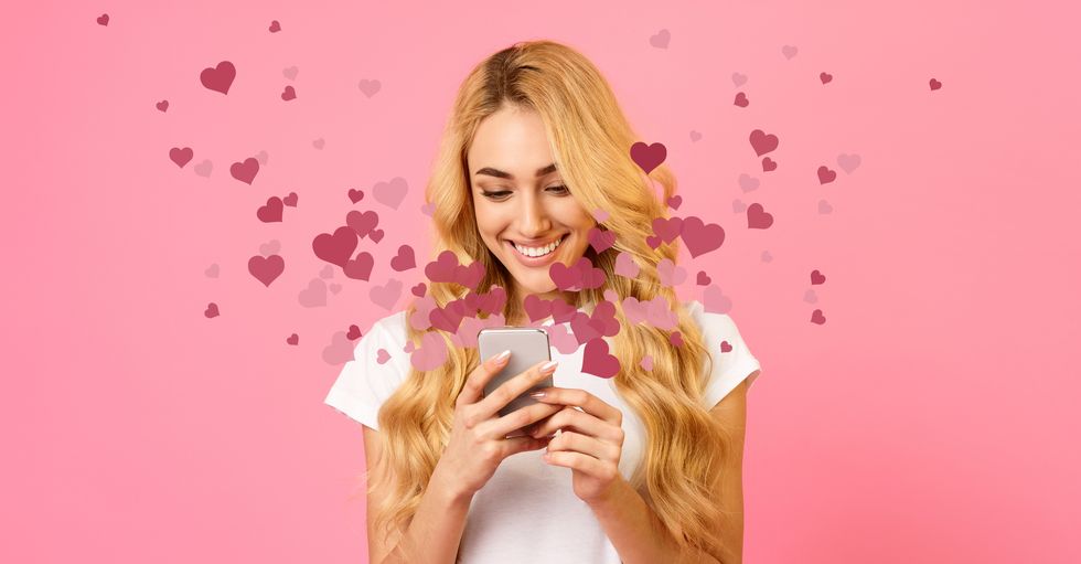 happy woman holding mobile phone with many hearts