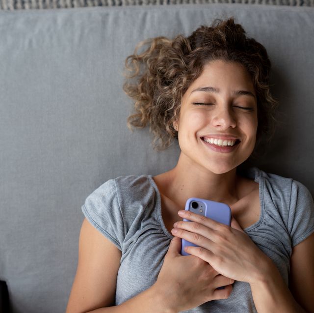 happy woman holding tight to her cell phone