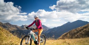 happy woman on electric mountain bike high up in european mountains