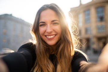 happy woman outside with sun in background