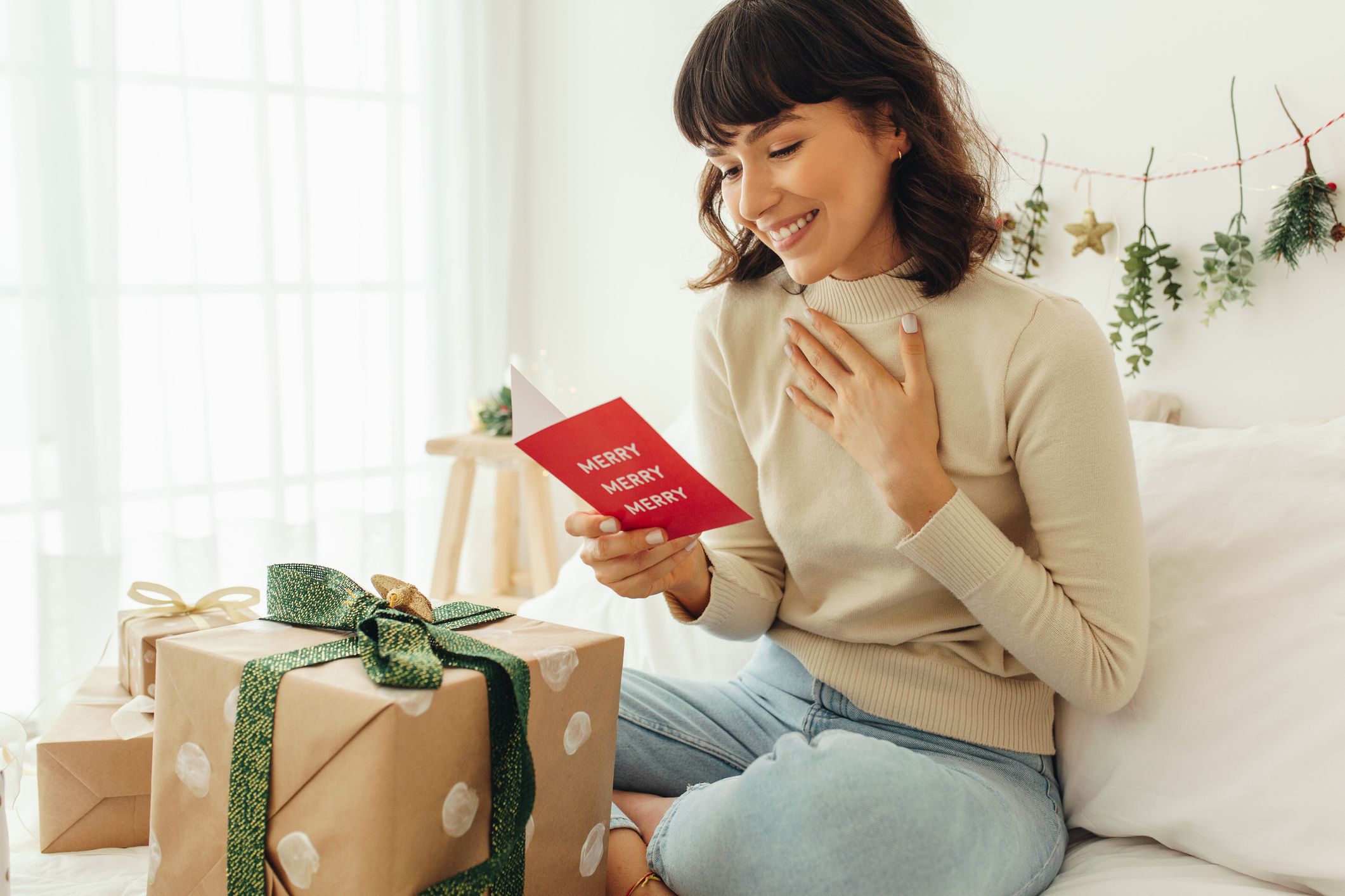 https://hips.hearstapps.com/hmg-prod/images/happy-woman-reading-a-christmas-greeting-card-royalty-free-image-1691786176.jpg