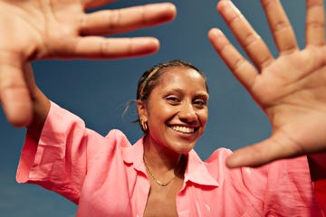 happy woman showing palms against sky