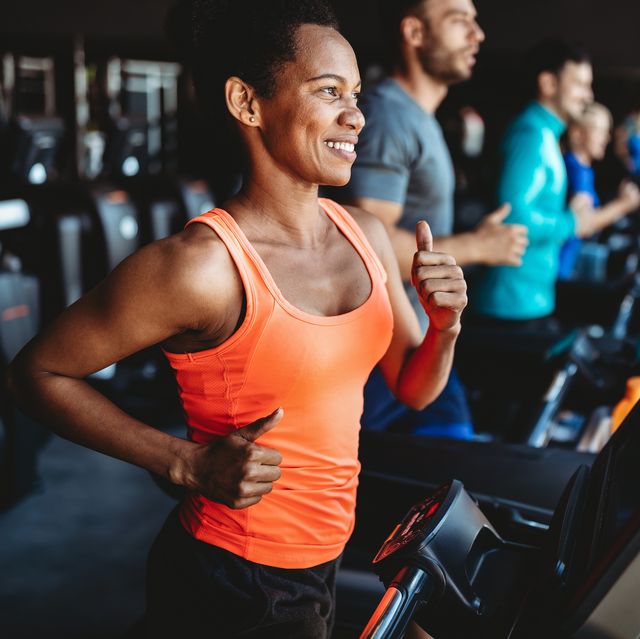 happy woman smiling and working out in gym