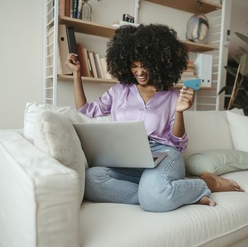 happy woman with credit card doing online shopping on laptop at home