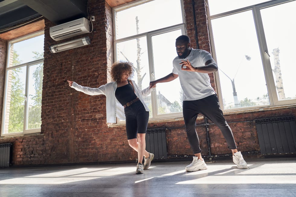 happy young couple practicing modern dancing in studio