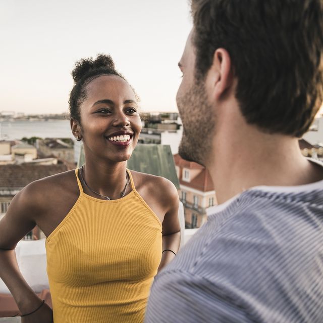 happy young couple talking on rooftop in the evening