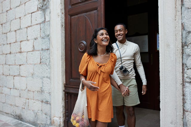 happy young couple walking out of doorway