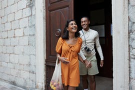 happy young couple walking out of doorway