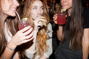 happy young friends enjoying drinks at a bar