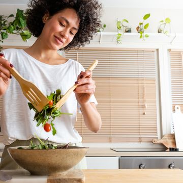 happy young multiracial woman mixing bowl of fresh salad copy spacehealthy lifestyle