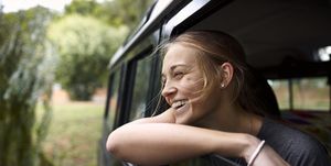 vrouw lachend uit raam auto
