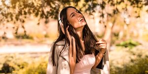 Happy Young Women is Listening to the Music in Park
