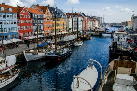 Het ruim 250 jaar oude Nyhavnkanaal wordt verlevendigd door zijn felgekleurde huizen cafs bars en restaurants terwijl in het kanaal nog veel historische houten schepen liggen De haven is een van d symbolen van Denemarken en heeft vooral in de zomer een grootstedelijke uitstraling  een perfecte plek om fotos te maken Op een warme dag kun je hier niet alleen de prachtige kleuren en tinten van de gebouwen fraai fotograferen maar ook het sociale leven en de sfeer van deze plek