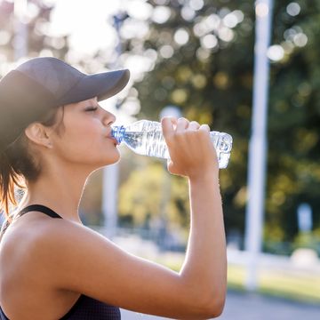 een vrouw drinkt water tijdens het hardlopen