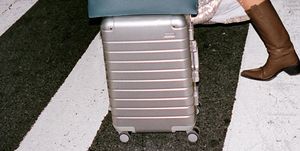 a person stands next to a suitcase