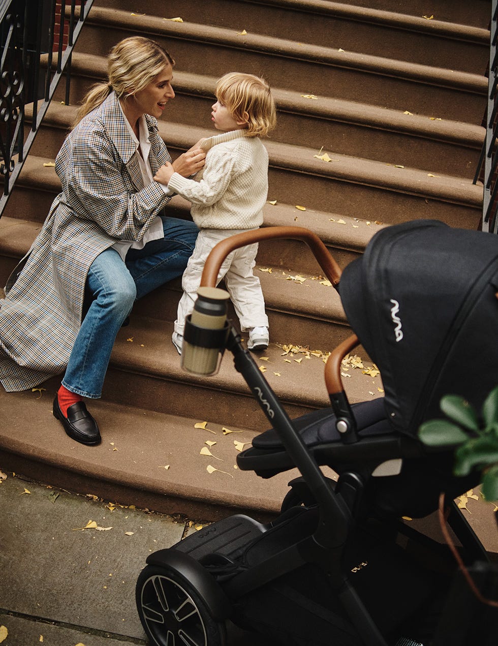 a person and a child sitting on a black object outside