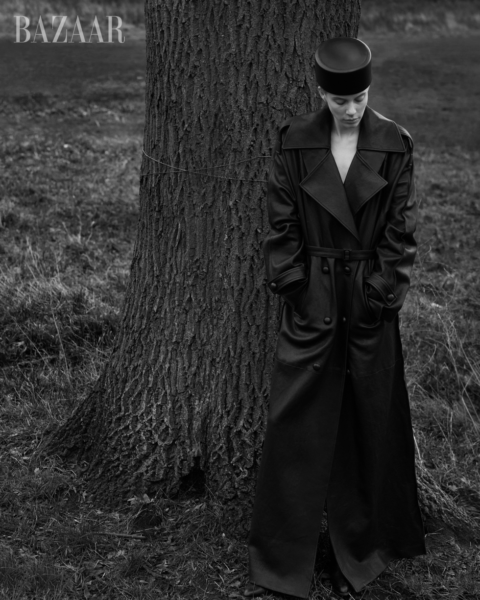 a man in a black robe standing next to a tree