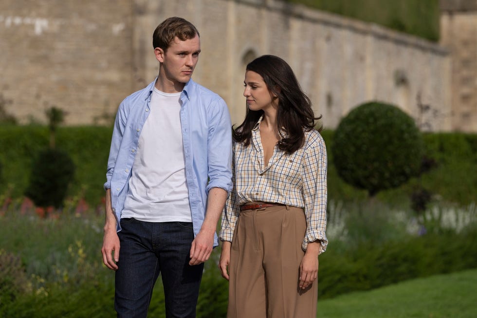 a man and a woman walking through gardens