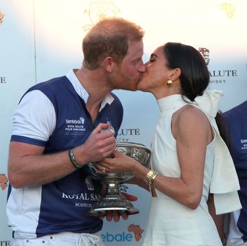 a man kissing a woman's cheek while holding a trophy
