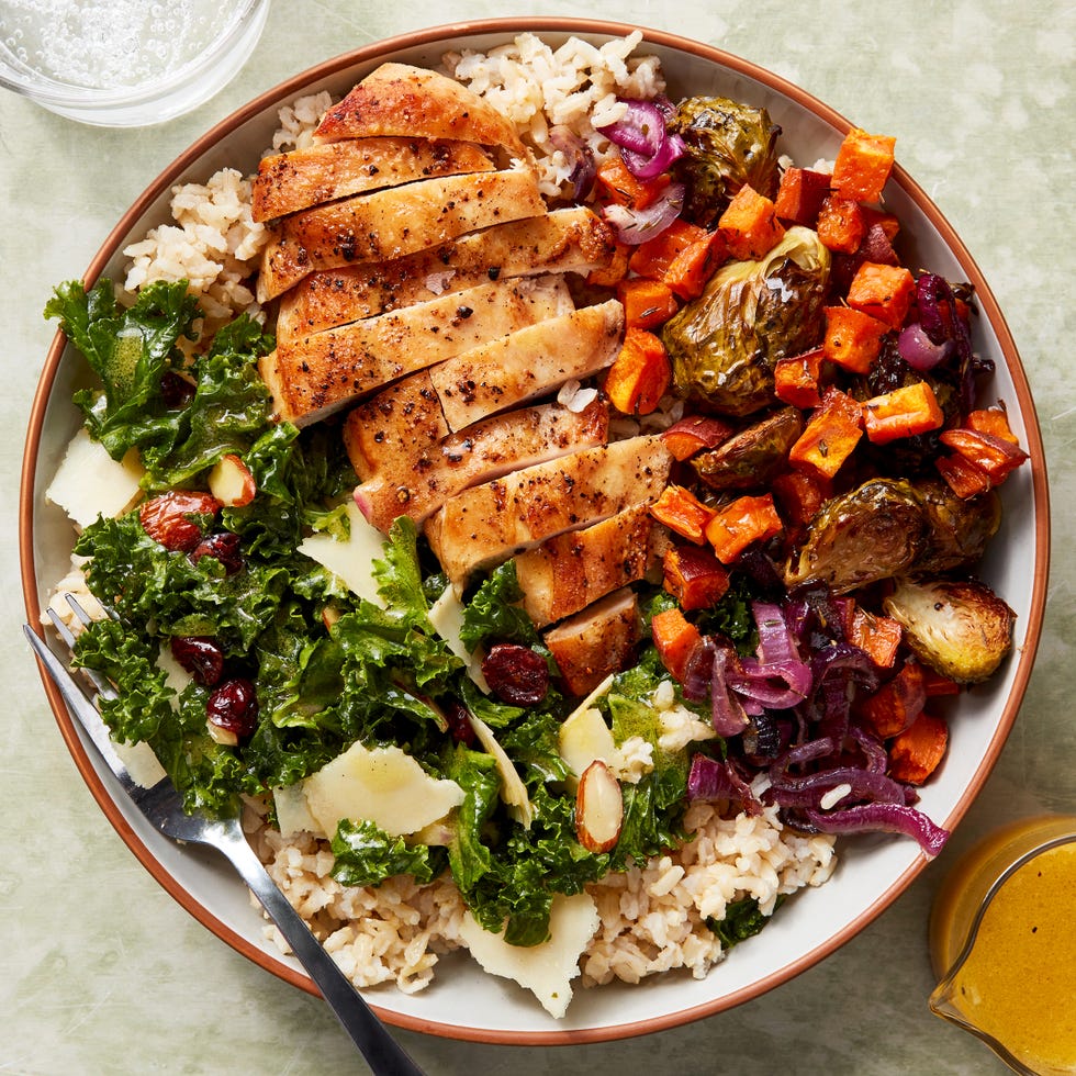 Chicken, kale salad and roasted sweet potatoes served in a bowl