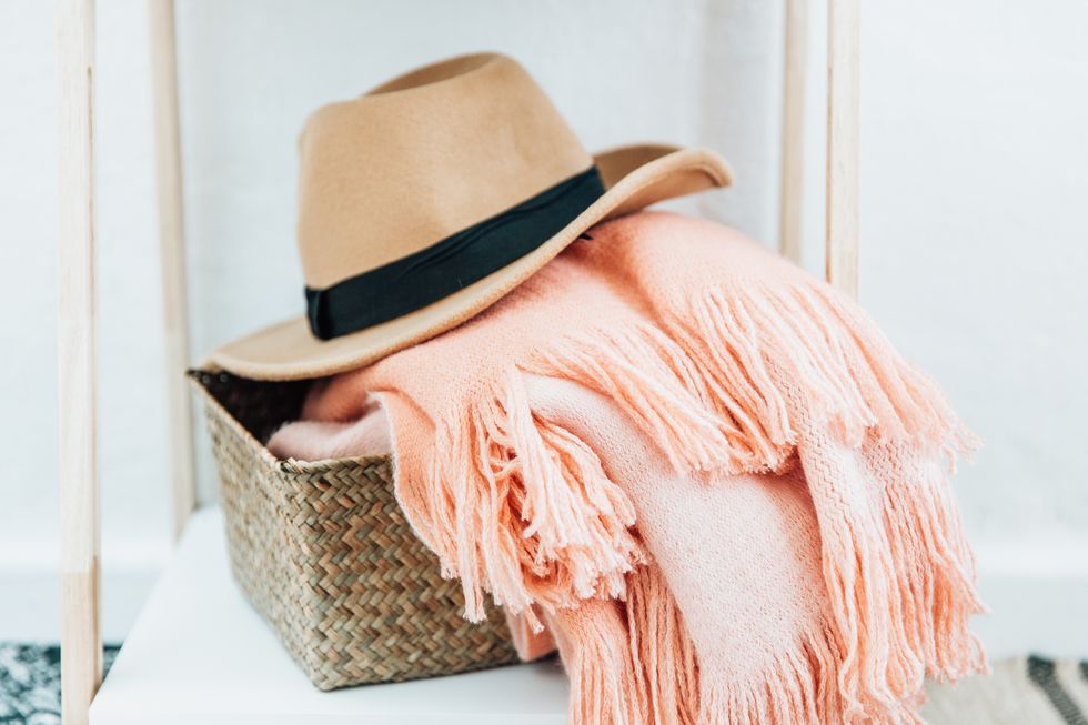 hat and blanket in basket cozy home
